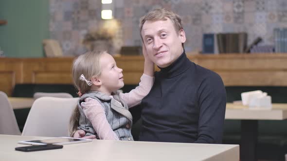 Happy Single Father Talking with Cute Little Daughter in Restaurant