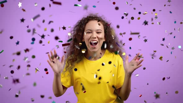 Happy Woman Dancing Having Fun Screaming WOW Rejoices Over Confetti Rain in Violet Studio