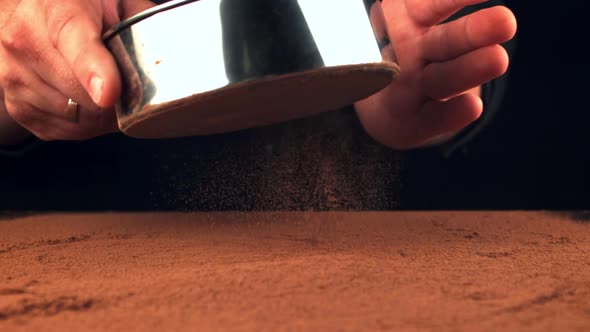 Super Slow Motion of the Man's Hand Through a Sieve of Cocoa