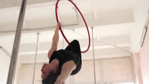 A Young Woman Gymnast Spins in an Acrobatic Ring