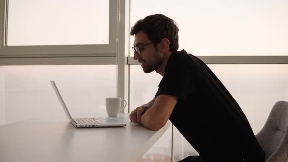 Relaxed Caucasian Man in Stylish Glasses Using Laptop Having Video Call