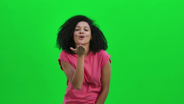 Portrait of Young Female African American Smiling and Showing Heart with Fingers Then Blowing Kiss