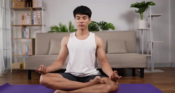 Man doing yoga meditation indoors