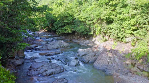 Water Higuero stream flowing between rocks in untouched nature, La Cuaba. Aerial drone low altitude