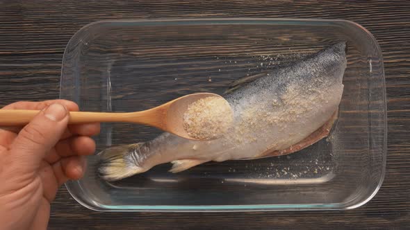 Closeup Top View of Hands Sprinkling a Red Char Fish with a Lemon Zest and Salt