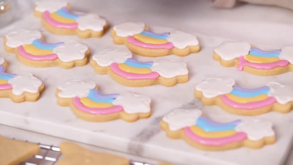 Step by step. Decorating unicorn shaped sugar cookies with royal icing for little girl birthday part