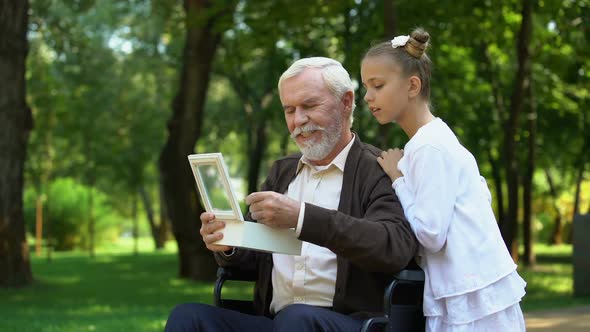 Grandfather in Wheelchair Showing Granddaughter Military Token, Telling Stories