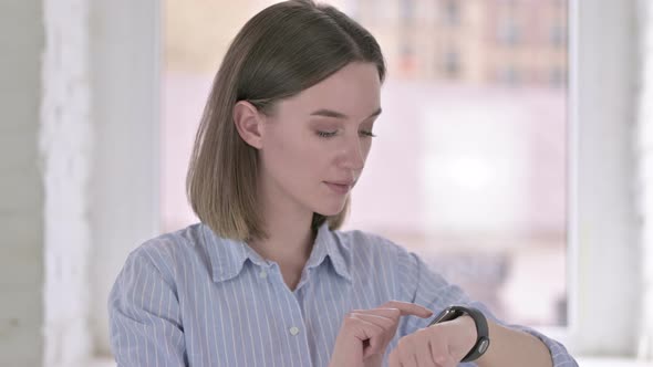 Portrait of Focused Young Professional Using Smart Watch