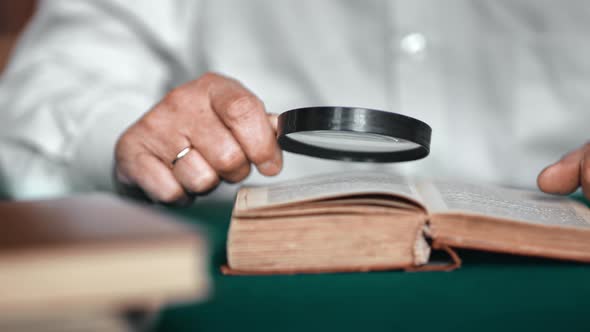 Closeup Elderly Man Hands Reading Old Retro Text Book Use Magnifying Glass Searching Information