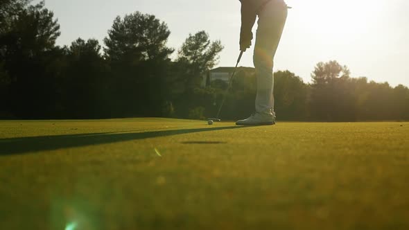 Golfer missing hole during sunset