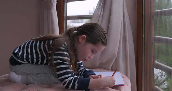 A Little Girl Drawing with Pencils at Home