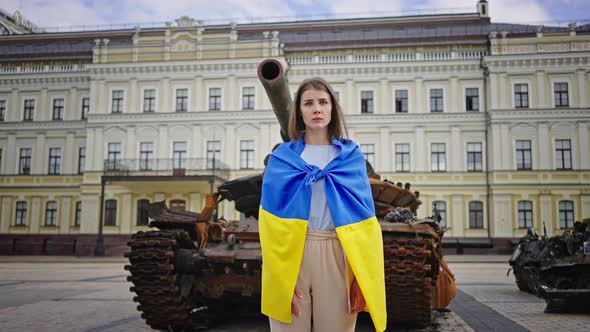 Woman Wrapped with Ukrainian Flag Makes Stop Gesture in Kyiv