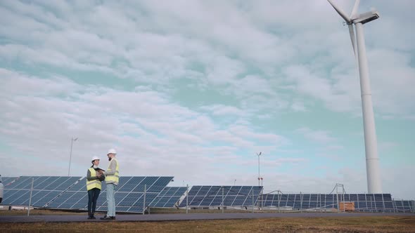 Ecological Engineers Use Digital Tablet and Talk at the Solar Panel Field