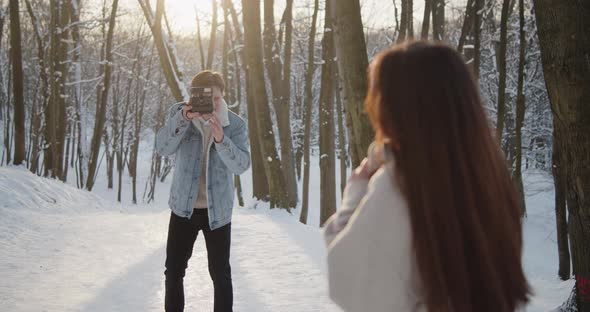 Happy Young Beautiful Couple Spend Time in Sunny Winter Forest Together
