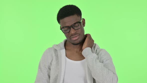 African Man Having Neck Pain on Green Background