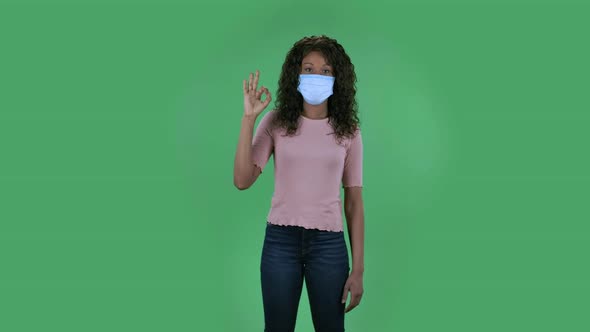 Portrait of Beautiful African American Young Woman in Medical Mask Is Looking Straight Sighs