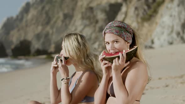 Side View of Happy Women Eating Watermelon and Looking at Camera