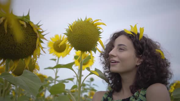 Portrait of Cute Fun Curly Playful Sensual Woman Standing in the Sunflower Field