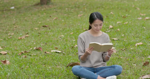 Woman read book on green grass