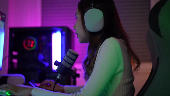 Gamer and E-Sport online of Asian woman playing online computer video game with lighting effect