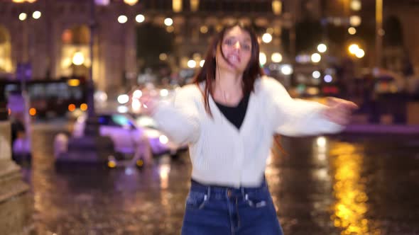 young woman performs modern dance steps on the street at night