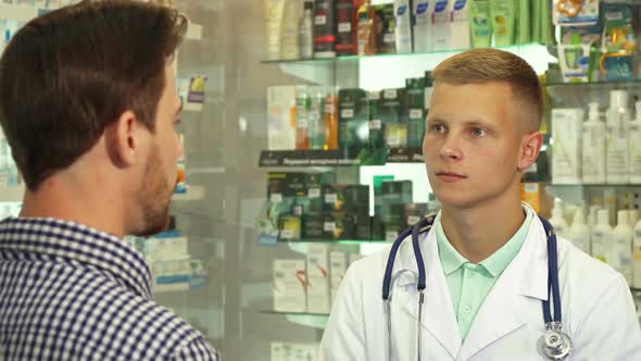 Doctor Listening To Patient in Drugstore