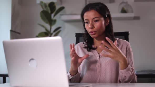 Woman Has Online Conversation and Uses Laptop Computer at Table in Modern Office Spbi