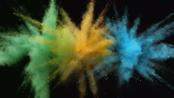 Colorful powder/particles fly after being exploded against black background. Slow Motion. alt