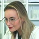 Attractive Young Female Doctor in Glasses Sitting at Desk in Office - VideoHive Item for Sale