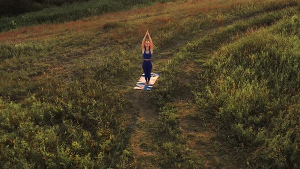 Woman Is Doing Yoga. Dawn, Green Field