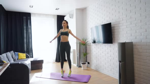 Fitness Woman Jumping While Training at Home
