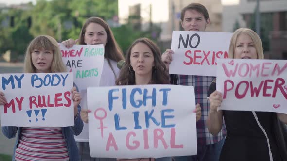 Five Caucasian People Shouting and Holding Feminism Banners with Slogans. Portrait of Men and Women