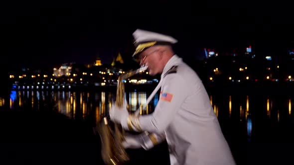 Saxophonist Plays at Night By the River