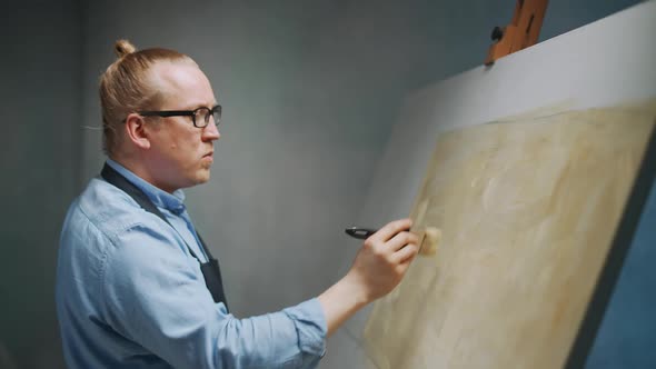 Slow Motion Creative Person at Work a Talented Adult Man Artist Covers the Canvas with Beige Oil