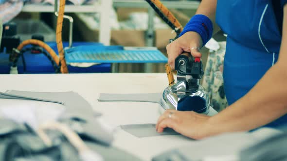 Plant Employee Is Ironing Cut-out Pieces of Fabric