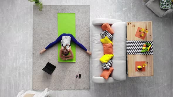 Young Sporty Attractive Woman Does Stretch at Home