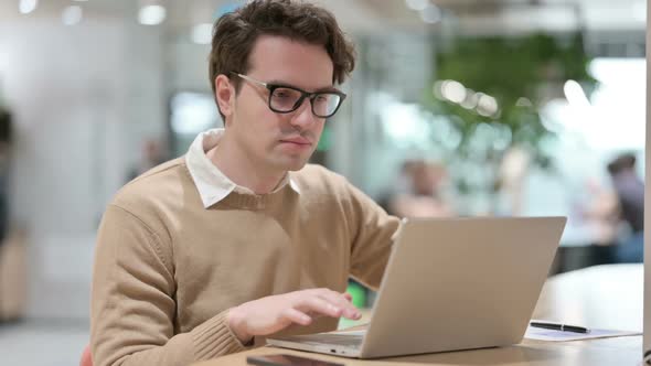 Man with Laptop Looking at the Camera