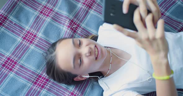 Top View of a Teenager Girl Playing Video Game Touching Smartphone Screen  She Having Fun at Home