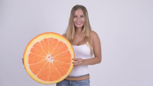 Happy Young Beautiful Blonde Woman with Orange Pillow As Healthy Concept