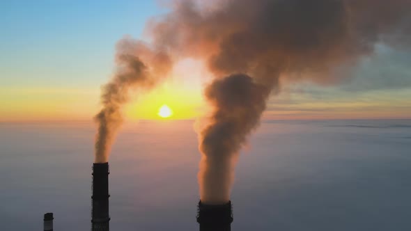 Aerial View of Coal Power Plant High Pipes with Black Smoke Moving Up Polluting Atmosphere at Sunset