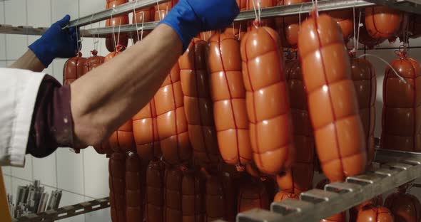 An Employee Hangs A Packed Sausage On A Container For Transportation To The Bakery