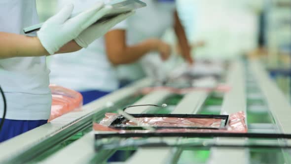 Workers assemble LCD monitors for a computer