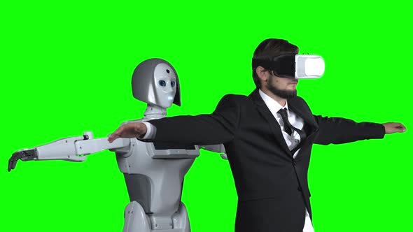 Man in Glasses of Virtual Reality Picks Up the Robot Repeats After Him. Green Screen