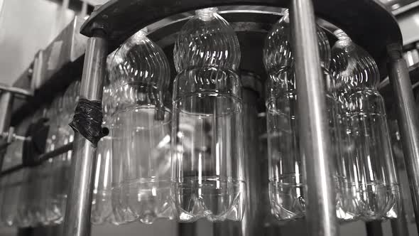 Plastic Bottles Travel Through an Automated Bottling Line for Drinking Water