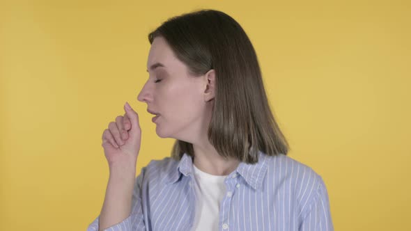 Sick Young Woman Coughing on Yellow Background