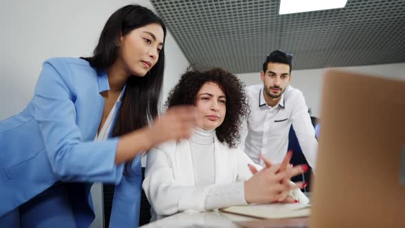 Group of Stressed Multiracial Coworkers Looking at Laptop Talking and Thinking