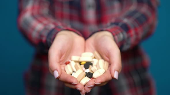 Woman Presenting a Handful of Pills