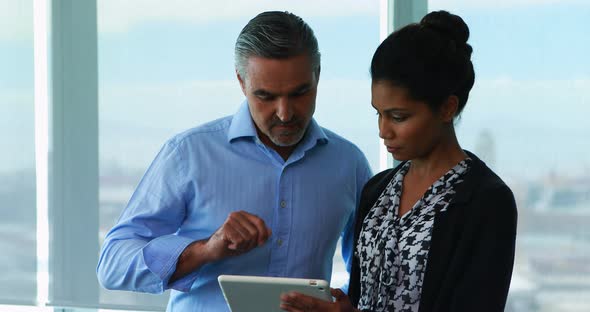 Executives discussing over digital tablet in office