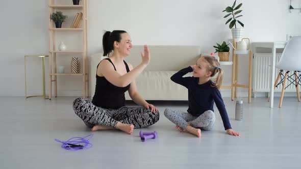 Sporty Woman Giving High Five to Little Daughter