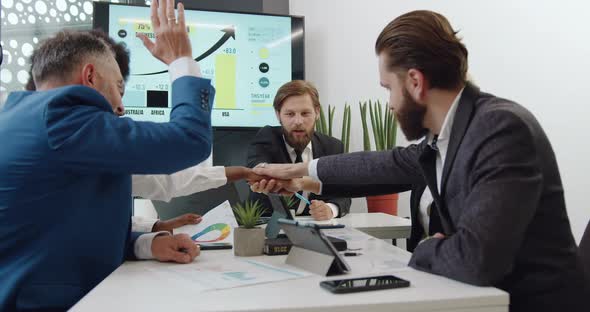 Multiracial Corporate Coworkers which Stacking Hands Together as a Sign Fruitful Collaboration